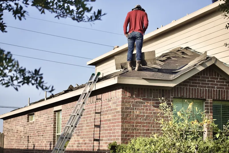 Professional roofer working on a residential roof in Queens Chapel Manor
